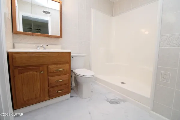 a bathroom with a sink vanity mirror and toilet