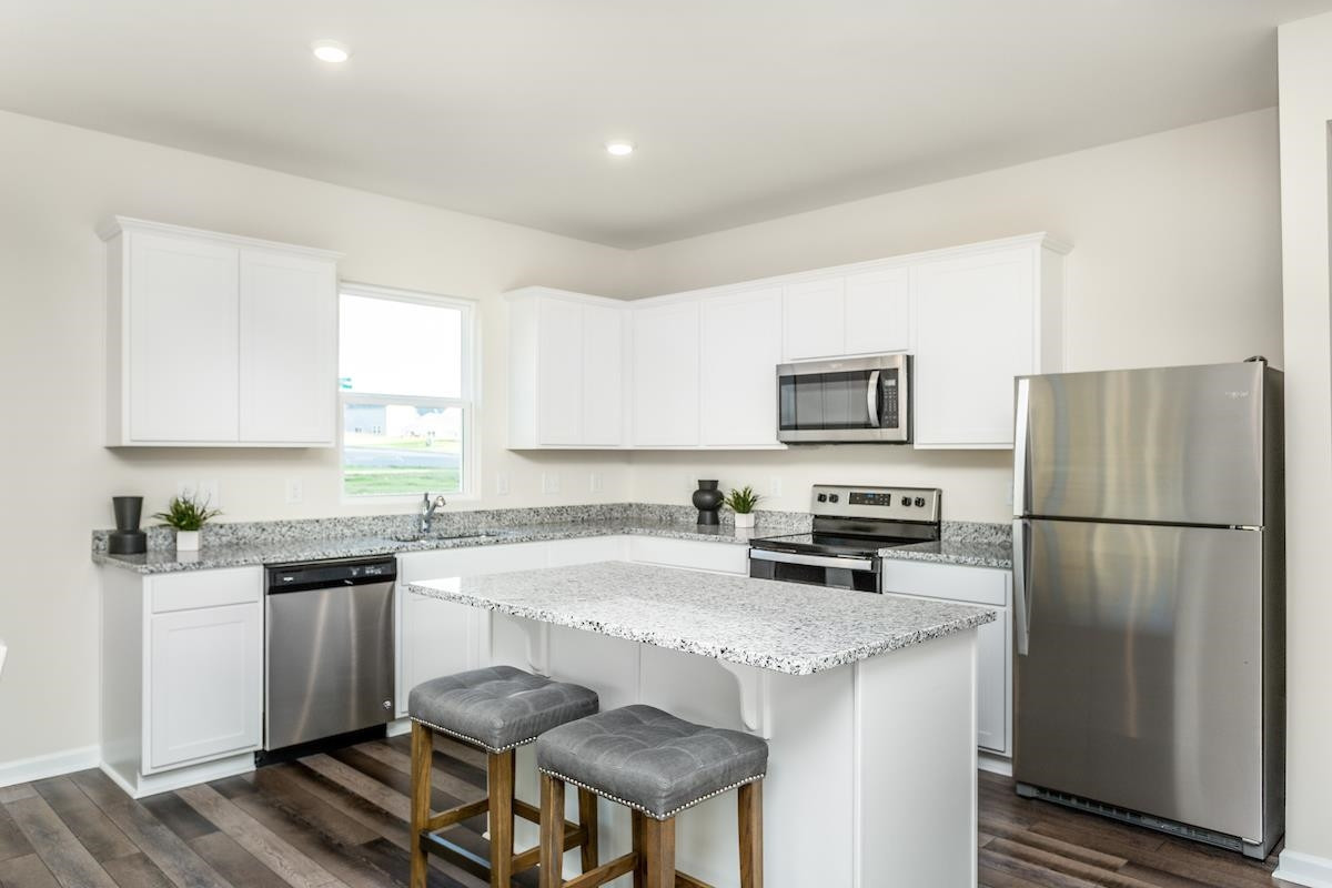 3521 New Town Road Raleigh, NC 27604 - Photo 7 of 18 a kitchen with stainless steel appliances granite countertop a refrigerator a stove a sink a stove a dining table and chairs