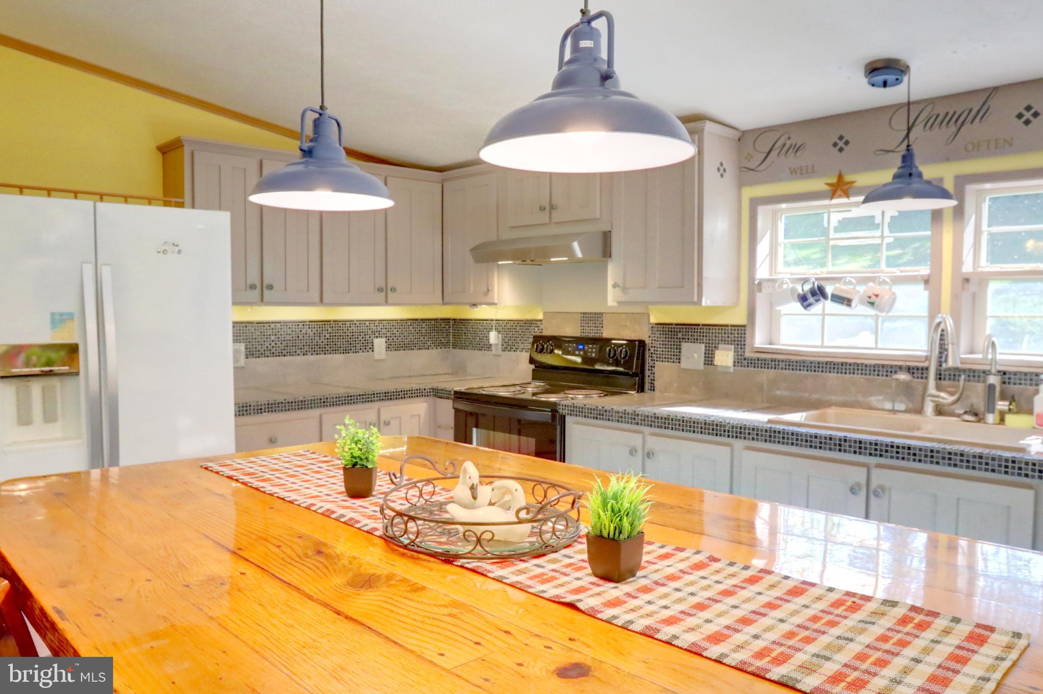 15792 Cross Mill Road Felton, PA 17322 - Photo 15 of 33 a kitchen with stainless steel appliances kitchen island granite countertop a sink a stove and a wooden floors