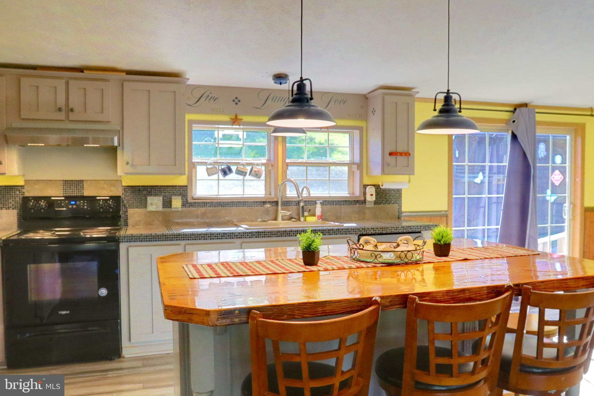 15792 Cross Mill Road Felton, PA 17322 - Photo 16 of 33 a kitchen with stainless steel appliances granite countertop a stove and a wooden cabinets