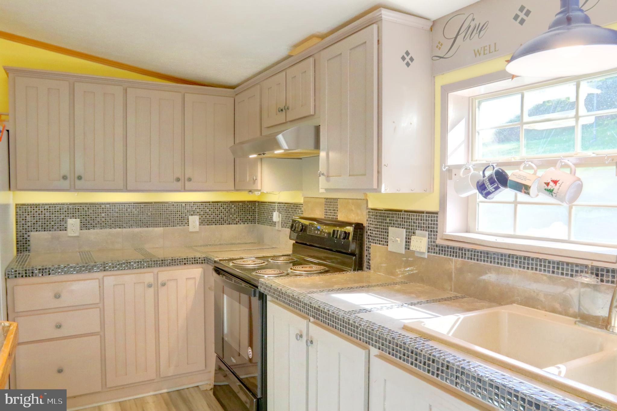 15792 Cross Mill Road Felton, PA 17322 - Photo 19 of 33 a kitchen with granite countertop a sink a stove and cabinets