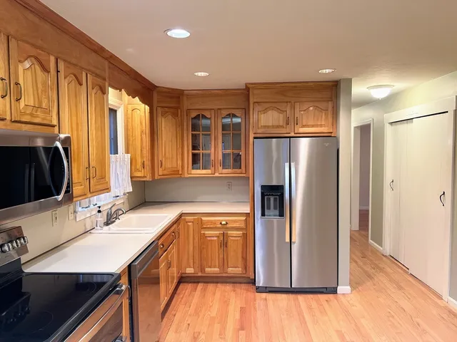 a bathroom with a granite countertop sink a toilet and a window