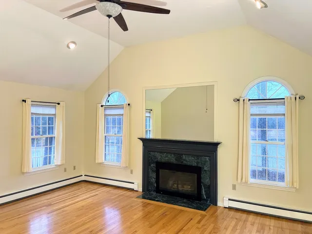 a living room with fireplace and wooden floor