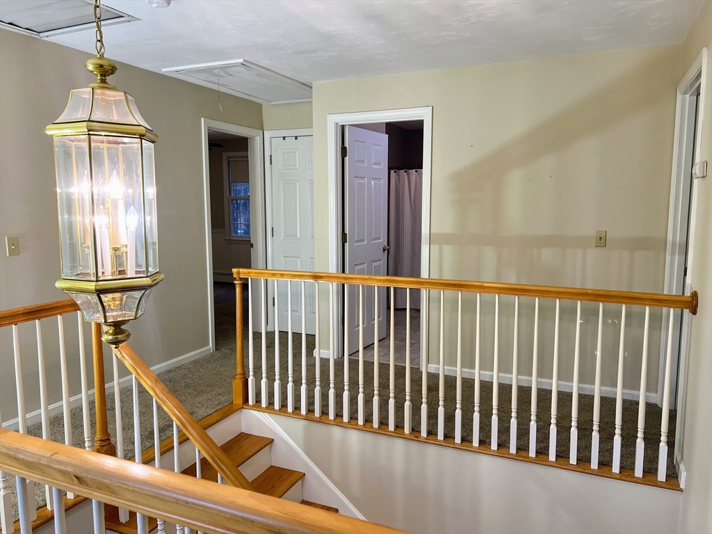 1565 West Street Wrentham, MA 02093 - Photo 32 of 41 a view of staircase with railing and a chandelier