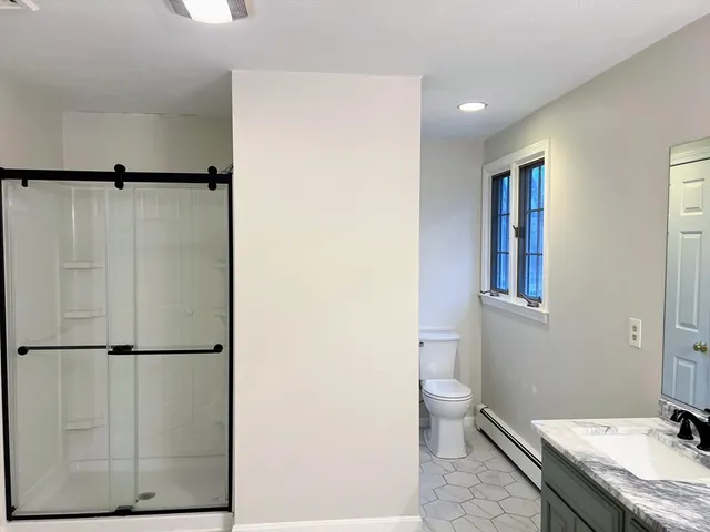 a bathroom with a granite countertop sink toilet and shower