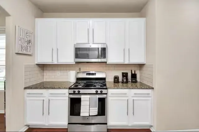a kitchen with appliances a sink and cabinets