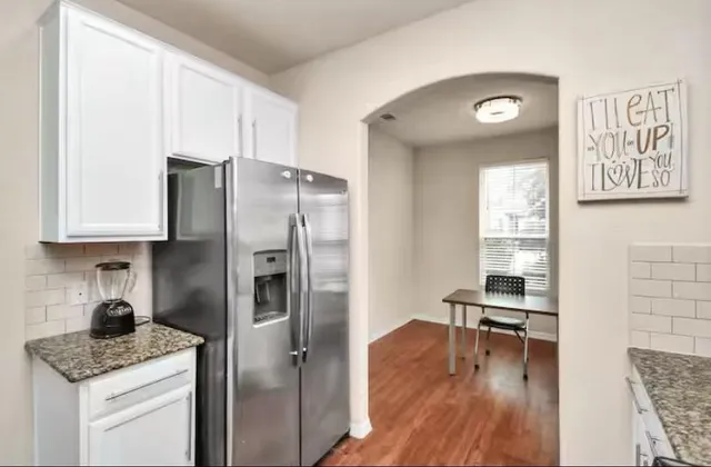 a kitchen with stainless steel appliances granite countertop a refrigerator and a stove top oven