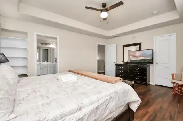 a bedroom with a bed and a flat tv screen on a dresser