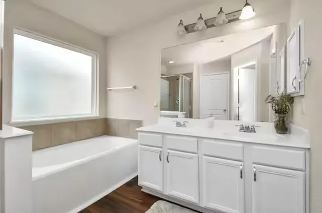 a bathroom with a tub a sink and mirror