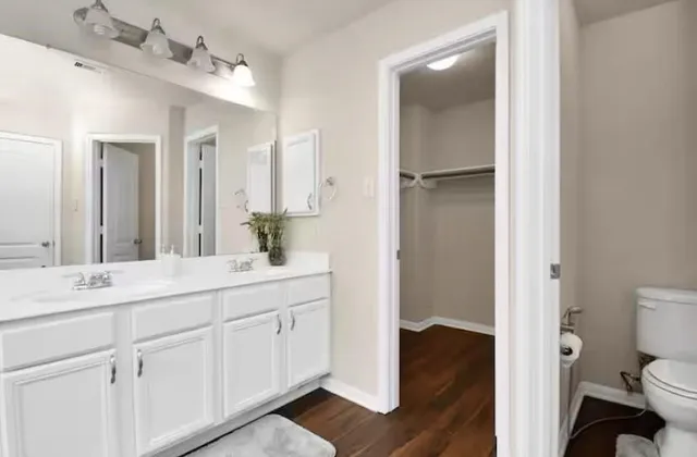 a en suite bathroom with a granite countertop sink toilet and shower