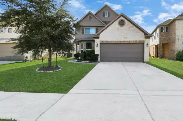 a front view of a house with a garden and yard