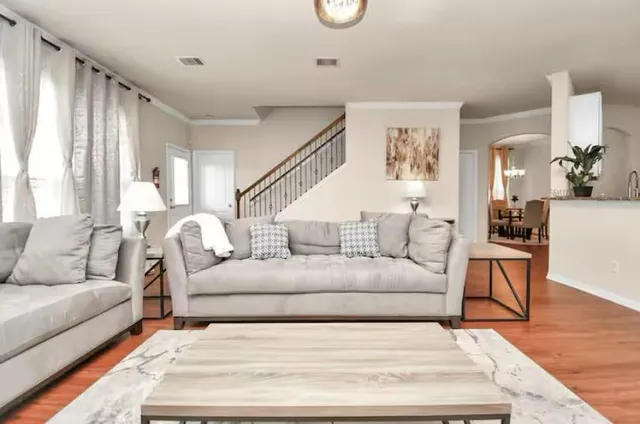 a living room with furniture and wooden floor