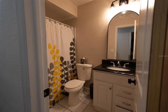 a bathroom with a sink a toilet and shower curtain