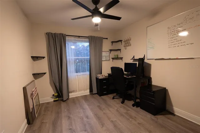 a view of a workspace with furniture and a ceiling fan