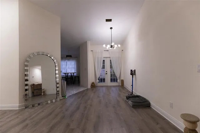 an empty room with wooden floor and a sink