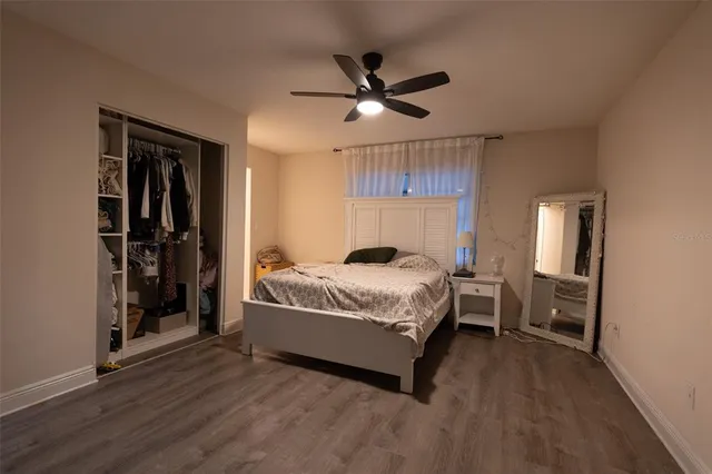 a bedroom with a bed and a ceiling fan
