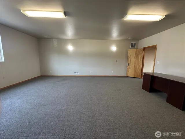 an empty room with windows and wooden floor