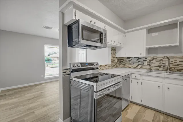 a kitchen with a sink stove and microwave