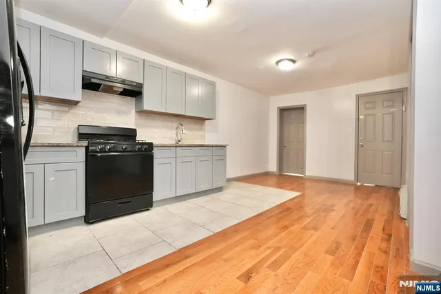 a kitchen with stainless steel appliances granite countertop a stove a refrigerator and a sink