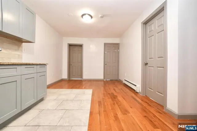 a view of a kitchen with white wooden cabinets