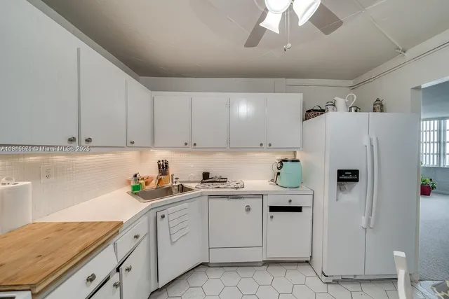 a kitchen with white cabinets and white appliances
