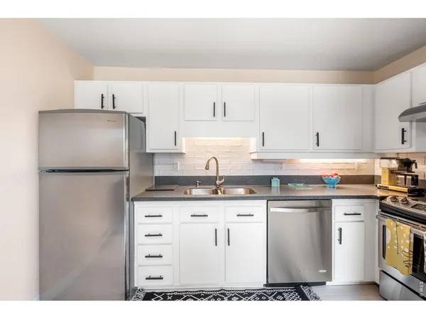 a kitchen with granite countertop a sink stainless steel appliances and cabinets