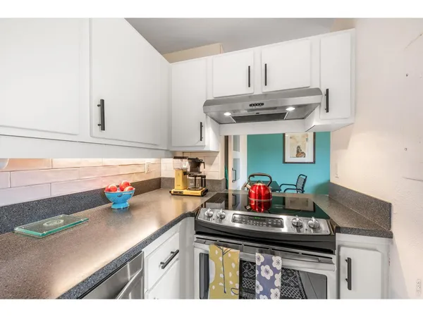 a kitchen with kitchen island stainless steel appliances a sink stove and cabinets