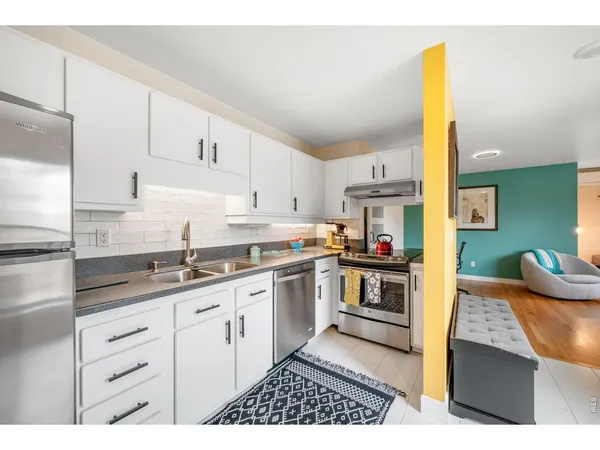 a kitchen with kitchen island granite countertop a sink and cabinets
