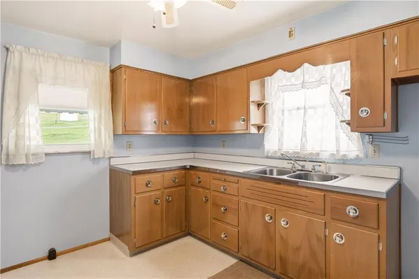 a kitchen with a sink window and cabinets