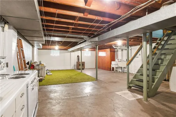 a view of an empty room with stairs and a dishwasher