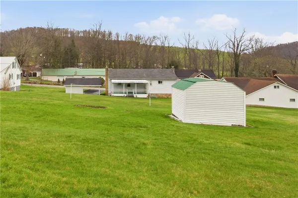 a view of a house with a yard and sitting area