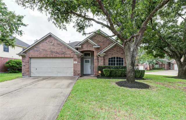 a front view of a house with a yard and trees