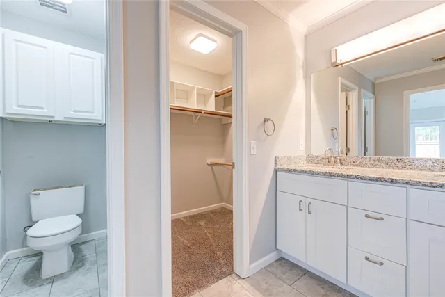 a bathroom with a granite countertop toilet sink and a mirror