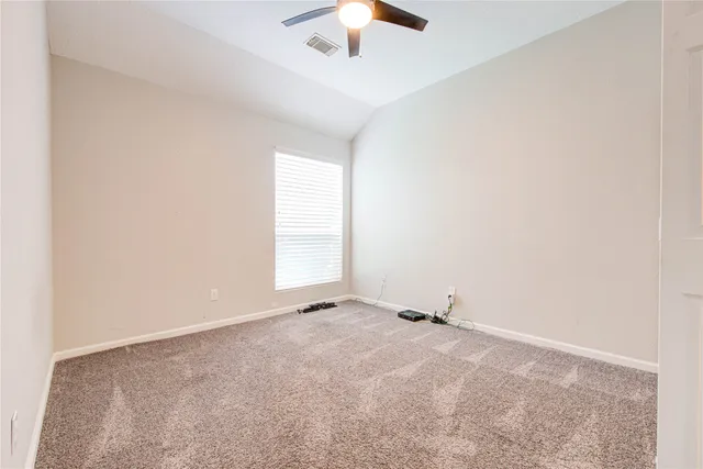 an empty room with a ceiling fan and a window