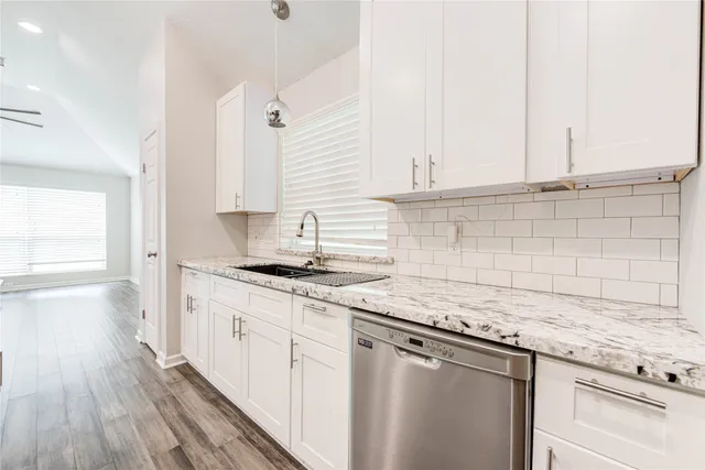 a kitchen with stainless steel appliances granite countertop a sink a stove and cabinets