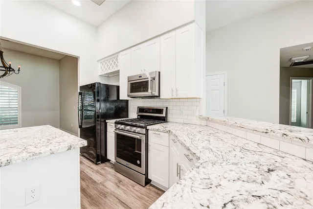 a kitchen with granite countertop a sink stove and refrigerator