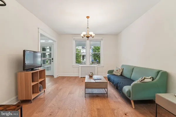 a living room with furniture a flat screen tv and a window