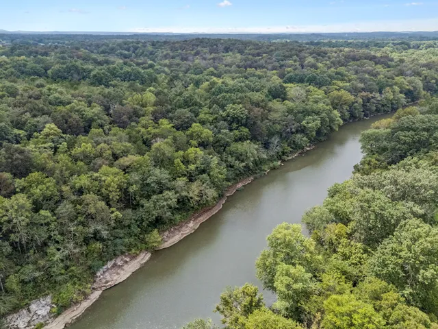 an aerial view of a residential houses with outdoor space and trees