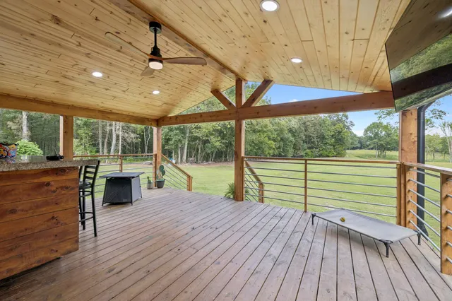 a kitchen with stainless steel appliances kitchen island granite countertop a stove a refrigerator a dining table and chairs with wooden floor