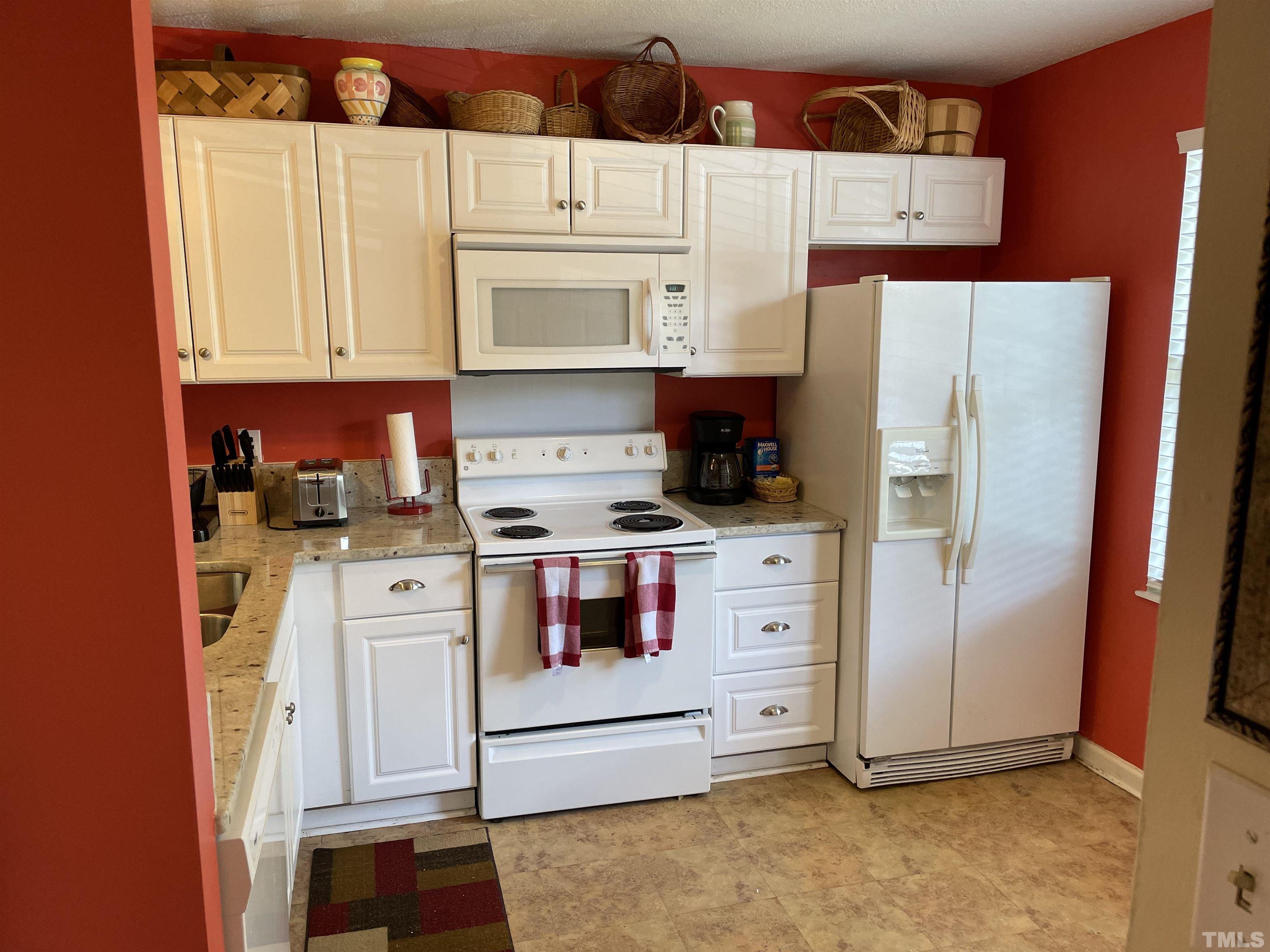 7841 Stephanie Lane Raleigh, NC 27615 - Photo 6 of 37 a kitchen with white cabinets and white appliances