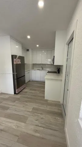 a view of a hallway with wooden floor and closet