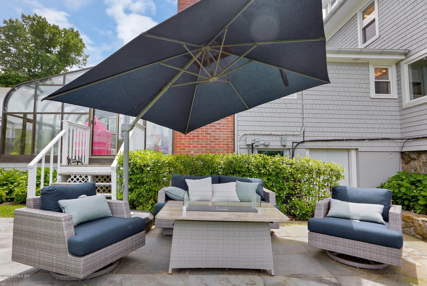 52 Arcadia Road Old Greenwich, CT 06870 - Photo 22 of 28 a view of a patio with couches table and a umbrella