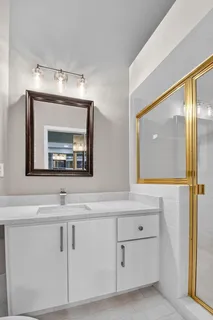 a bathroom with a sink a toilet a mirror and a window