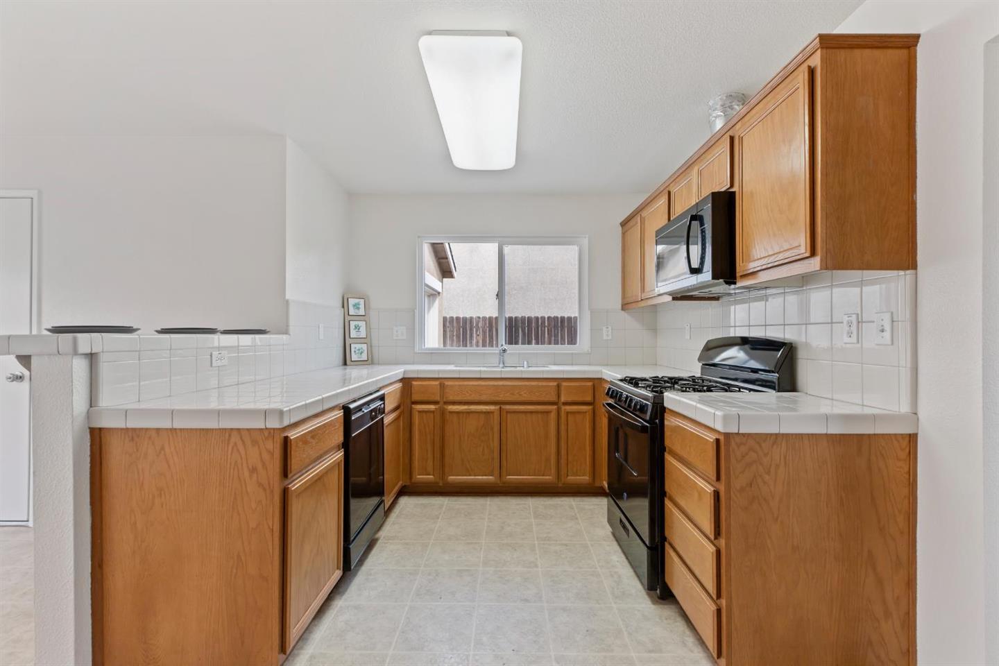 4347 Mathias Way Merced, CA 95348 - Photo 9 of 20 a kitchen with stainless steel appliances granite countertop a sink and a stove