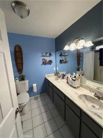 a bathroom with a double vanity sink mirror and toilet