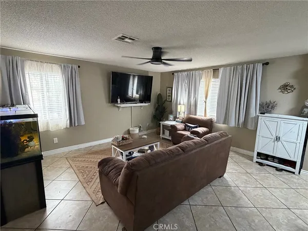 a living room with furniture a flat screen tv and a window