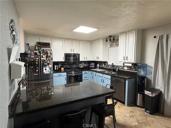 a kitchen with a refrigerator and a stove top oven