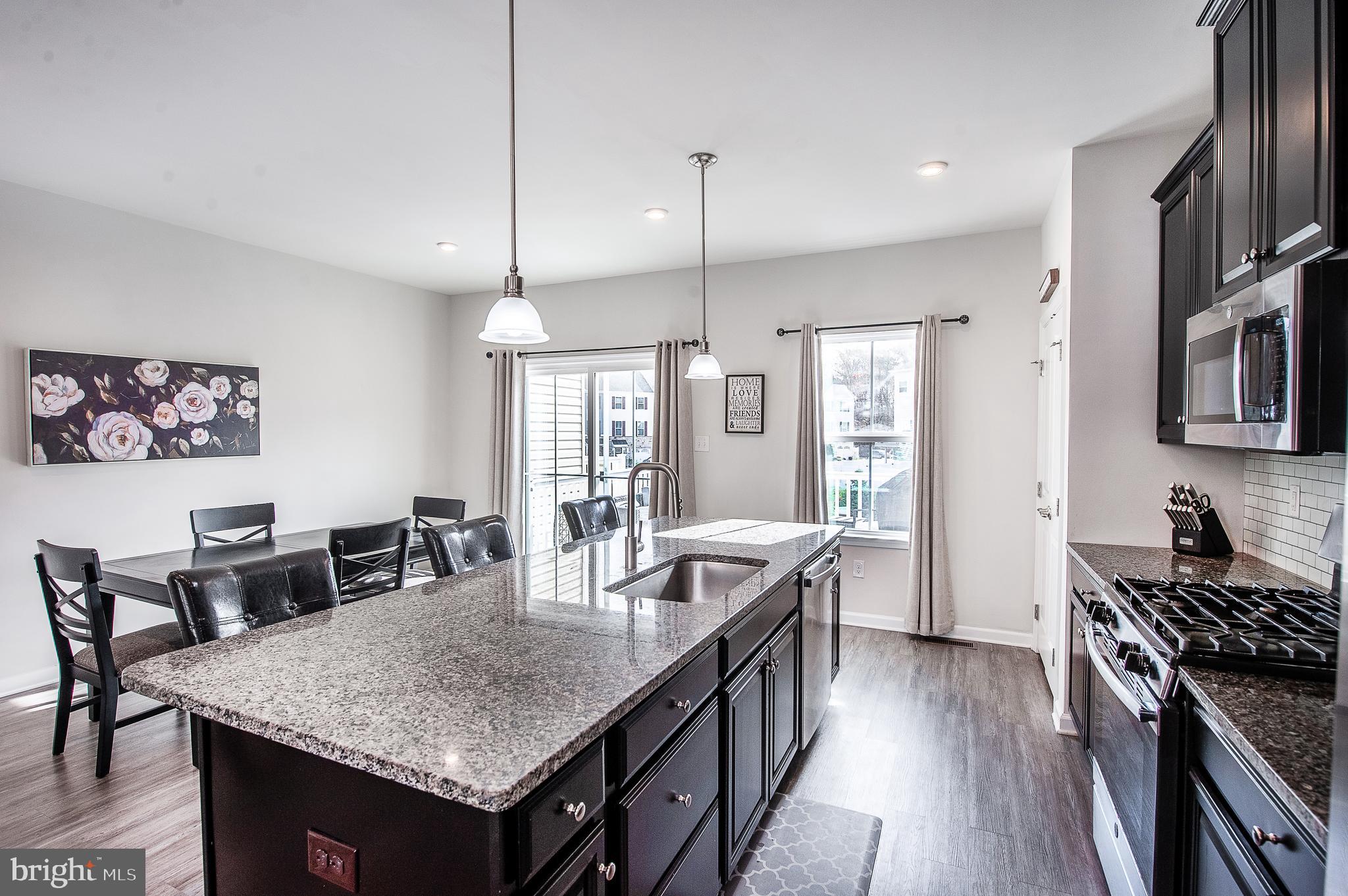 2804 Lamington Court Clarksboro, NJ 08020 - Photo 9 of 24 a kitchen with granite countertop a stove a sink a dining table and chairs