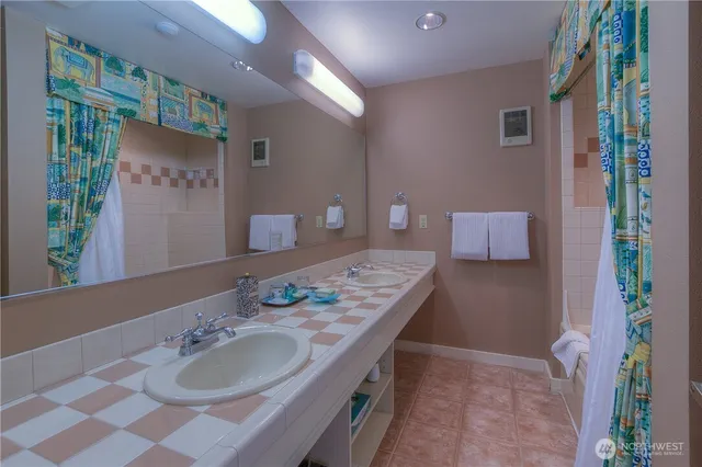 a bathroom with a tub sink and mirror