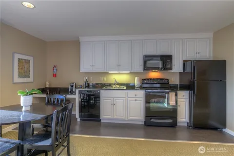 a kitchen with a refrigerator and a stove top oven